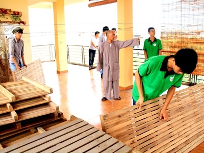 Sinh viên tình nguyện giúp thầy Thích Thiện Hóa dọn chỗ ở cho sĩ tử ở chùa Bằng (Hà Nội). Ảnh: Trường Phong.